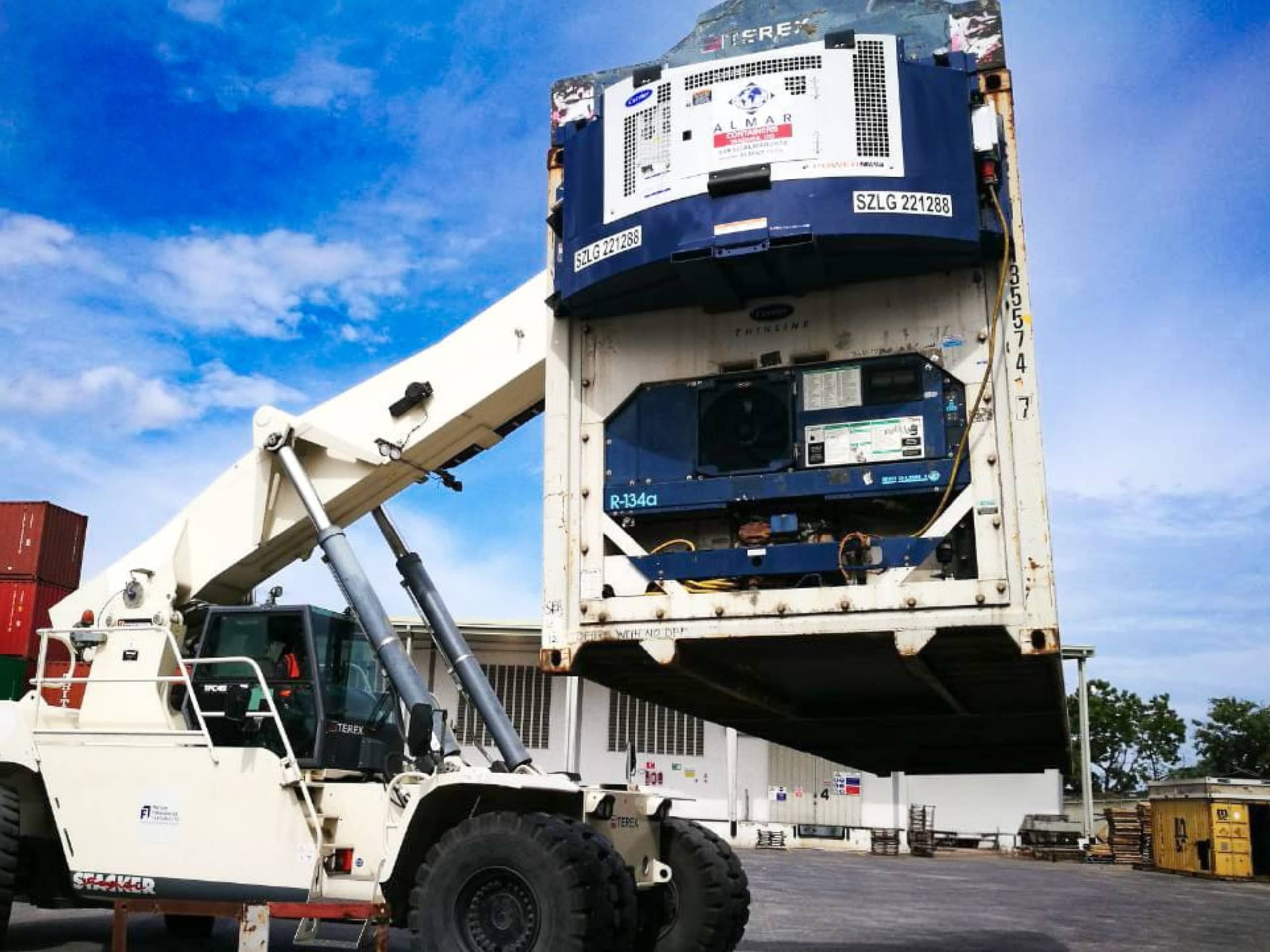 A blue Almar clip-on reefer genset being mounted onto a refrigerated shipping container.